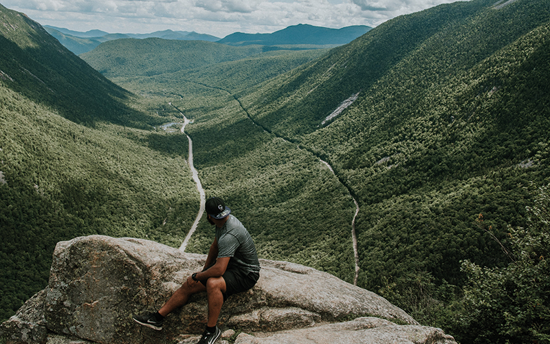 Man sat looking over his shoulder at the valley