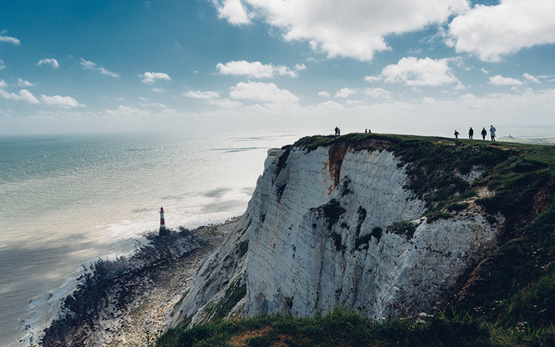 people walking along a cliff