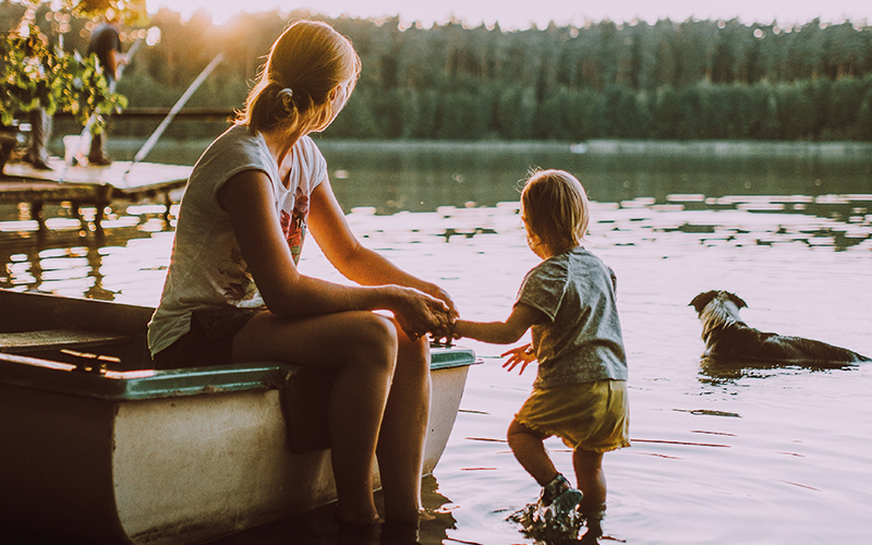 Mother, child and dog looking out over the water