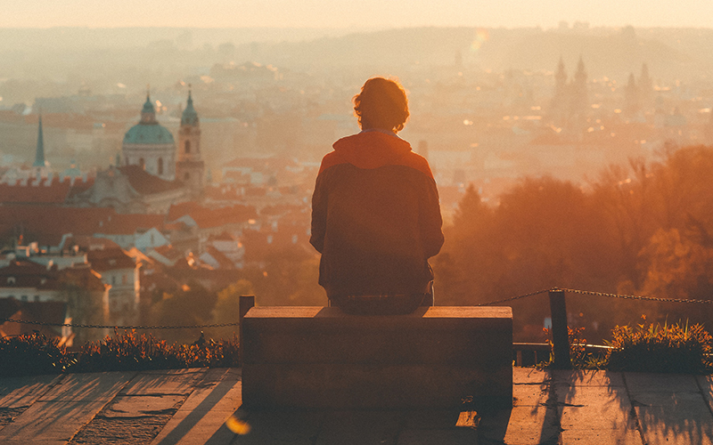 Man sat on bench looking out over city