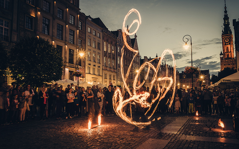 People gathered round watching street performer