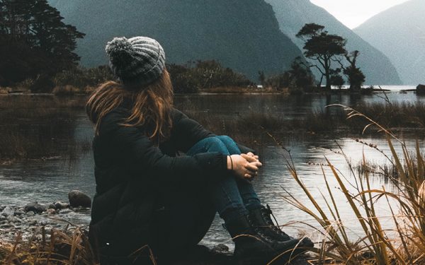 Woman sat looking out over water