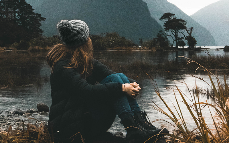 Woman sat looking out over water