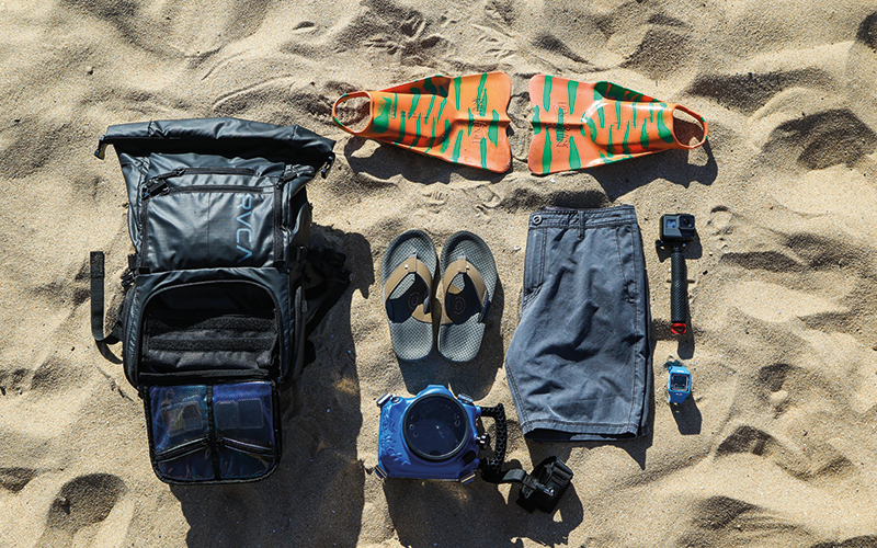 Clothes and backpack items on the sand