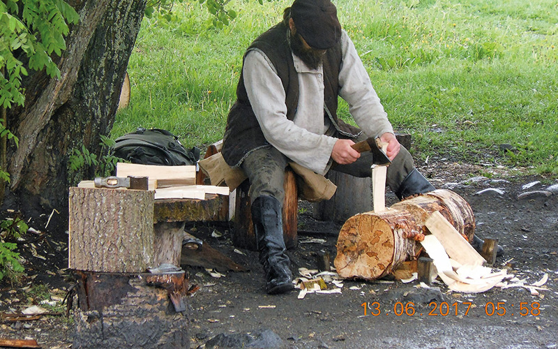 Man sat chopping logs