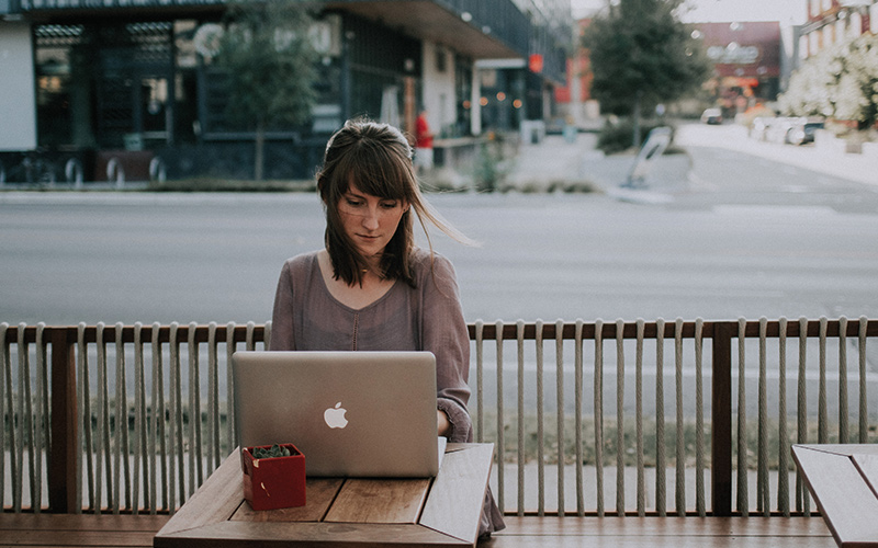 Woman sat on laptop outside