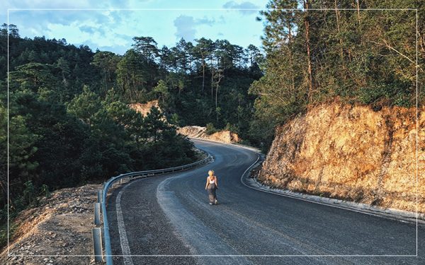 Woman walking alone on winding rode