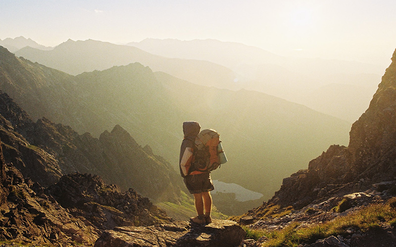 man looking out over view in mountains